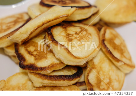 A stack of fritters on a white plate on the table. A stack of fritters on a white plate on the table. 47334337