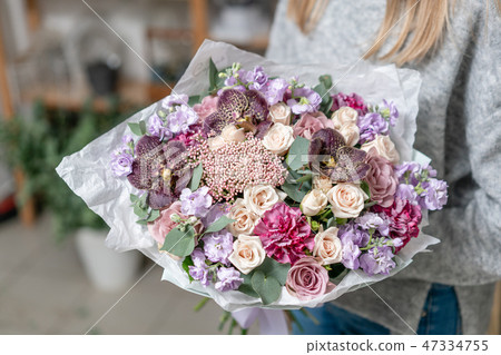 beautiful fresh cut bouquet of mixed flowers in woman hand. the work of the florist at a flower shop 47334755