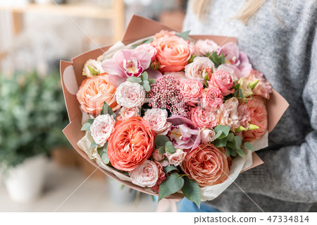 beautiful fresh cut bouquet of mixed flowers in woman hand. the work of the florist at a flower shop beautiful fresh cut bouquet of mixed flowers in woman hand. the work of the florist at a flower shop 47334814