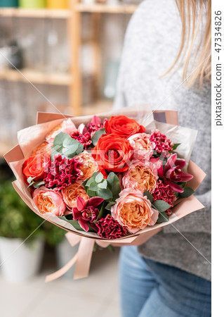 beautiful fresh cut bouquet of mixed flowers in woman hand. the work of the florist at a flower shop 47334826