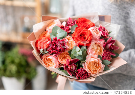 beautiful fresh cut bouquet of mixed flowers in woman hand. the work of the florist at a flower shop 47334838