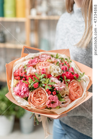 beautiful fresh cut bouquet of mixed flowers in woman hand. the work of the florist at a flower shop 47334868