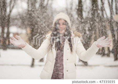 Young beautiful woman is enjoying the snow 47335035