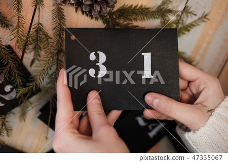 The girl is holding a calendar sheet. 31th of December. New Year's Eve. The girl is holding a calendar sheet. 31th of December. New Year's Eve. 47335067
