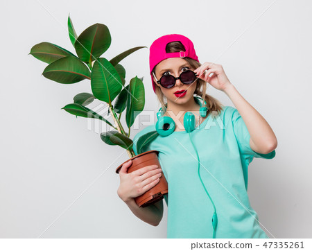 girl in pink cap and blue t-shirt with green plant 47335261