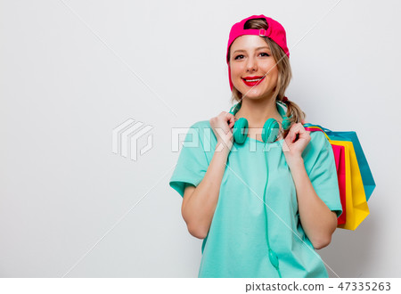 girl in pink cap and blue t-shirt with shopping bags girl in pink cap and blue t-shirt with shopping bags 47335263