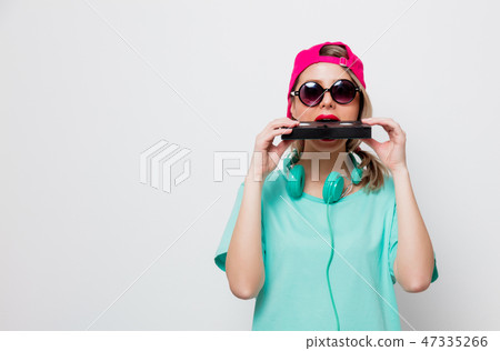girl in pink cap and blue t-shirt with VHS cassette girl in pink cap and blue t-shirt with VHS cassette 47335266