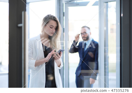 A man and a woman at the entrance to the office door are talking, acquaintance. A man and a woman at the entrance to the office door are talking, acquaintance. 47335276