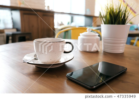 Coffee drink on wooden table with blur cafeteria as background. 47335949
