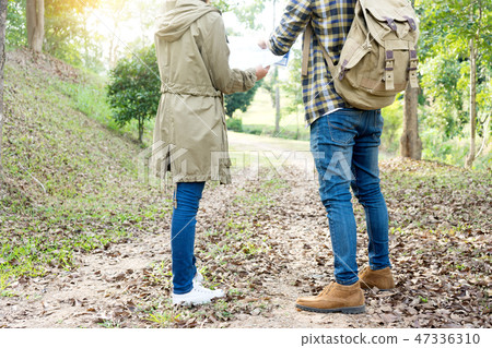 man and woman walk in the forest 47336310