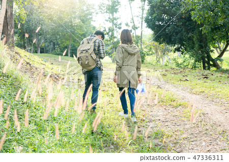man and woman walk in the forest 47336311