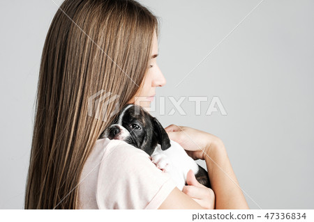 Young beautiful girl hugging a puppy of a French bulldog 47336834