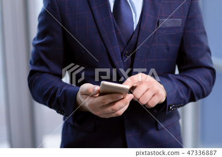 Phone in the hands of a businessman businessman in a business suit. 47336887