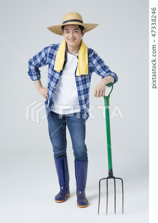 Agriculture industry, farming and people concept. Young farmer gesturing over gray background. 133 Agriculture industry, farming and people concept. Young farmer gesturing over gray background. 133 47338246