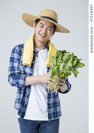 Agriculture industry, farming and people concept. Young farmer gesturing over gray background. 026 Agriculture industry, farming and people concept. Young farmer gesturing over gray background. 026 47338407