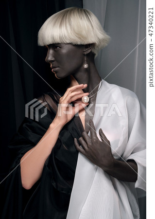 Portrait of a girl half black and white. Half-breed, mixing races, African and european. 47340221