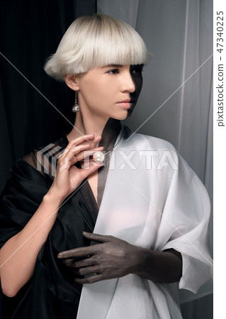 Portrait of a girl half black and white. Half-breed, mixing races, African and european. 47340225