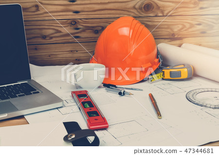 Measurement tool with helmet, coffee on blueprint 47344681