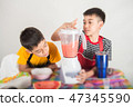 Little boys blend water melone juice by using blender at home 47345590