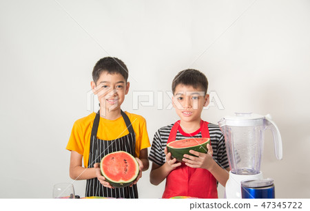 Little boys blend water melone juice by using blender at home Little boys blend water melone juice by using blender at home 47345722