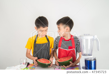 Little boys blend water melone juice by using blender at home Little boys blend water melone juice by using blender at home 47345723