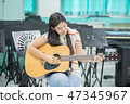 Teacher teach keyboard electone instument to a boy in class room 47345967
