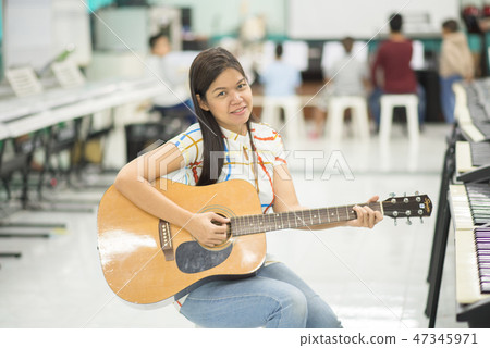 Asian girl studyguitar in the music classroom Asian girl studyguitar in the music classroom 47345971