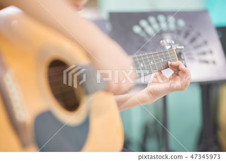 Asian girl studyguitar in the music classroom Asian girl studyguitar in the music classroom 47345973