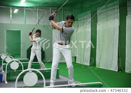 Men and women practicing golf Men and women practicing golf 47346332