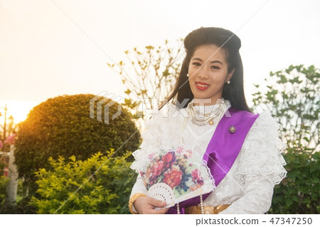 Pretty Thai lady standing and hold paper fan. Pretty Thai lady standing and hold paper fan. 47347250