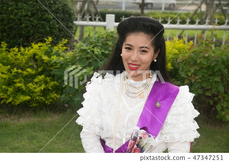 Pretty Thai lady standing and hold paper fan. Pretty Thai lady standing and hold paper fan. 47347251