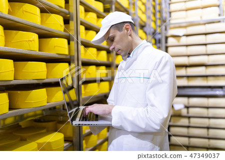 worker with a laptop in his hands at the cheese warehouse worker with a laptop in his hands at the cheese warehouse 47349037