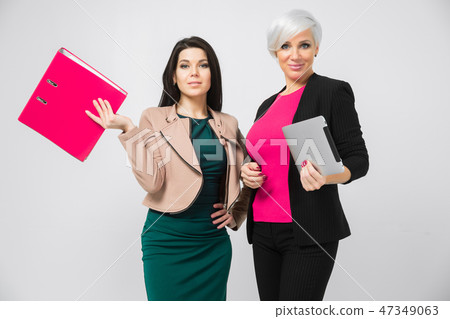 Portrait of two ladies with document folder and tablet in hand isolated on white background Portrait of two ladies with document folder and tablet in hand isolated on white background 47349063