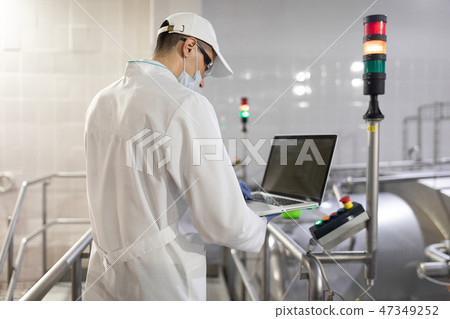 An employee with a laptop in his hands at the dairy plant An employee with a laptop in his hands at the dairy plant 47349252