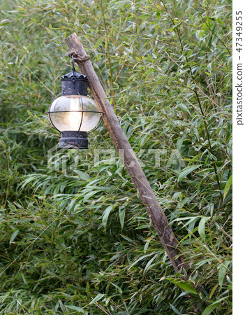 Old lantern hanging on a wooden pole Old lantern hanging on a wooden pole 47349255