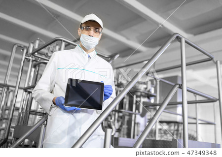 technologist shows a blank screen of the tablet at the dairy plant technologist shows a blank screen of the tablet at the dairy plant 47349348
