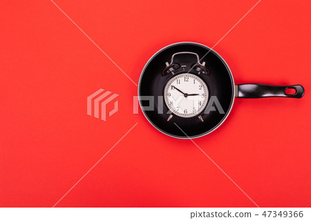 top view of alarm Clock in pan isolated on red background 47349366
