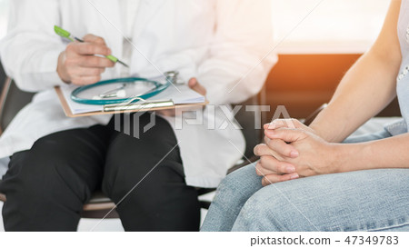 Doctor consulting stressful woman patient Doctor consulting stressful woman patient 47349783