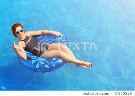 Woman relax on inflatable ring in sea water Woman relax on inflatable ring in sea water 47350559