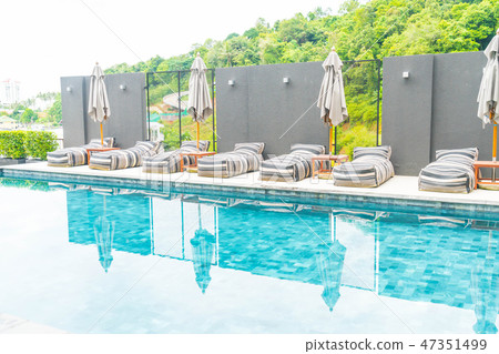 umbrella and chair around outdoor swimming pool umbrella and chair around outdoor swimming pool 47351499