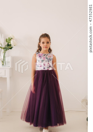 Happy child female in purple dress. Beautiful makeup and hairstyle 47352981
