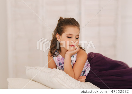 Happy child female in purple dress. Beautiful makeup and hairstyle Happy child female in purple dress. Beautiful makeup and hairstyle 47352982