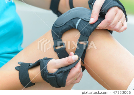 rollerskater putting on protector pads on her leg rollerskater putting on protector pads on her leg 47353006