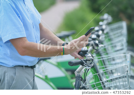 Renting bicycle from urban bicycle sharing station Renting bicycle from urban bicycle sharing station 47353292