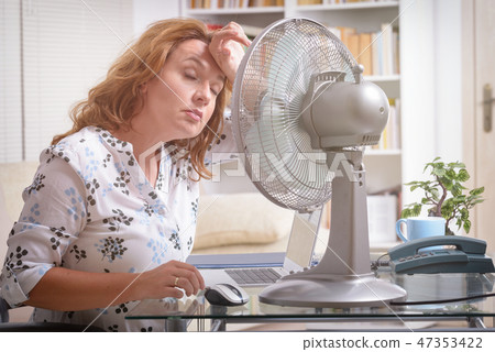 Woman suffers from heat in the office or at home 47353422