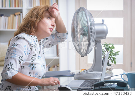 Woman suffers from heat in the office or at home 47353423