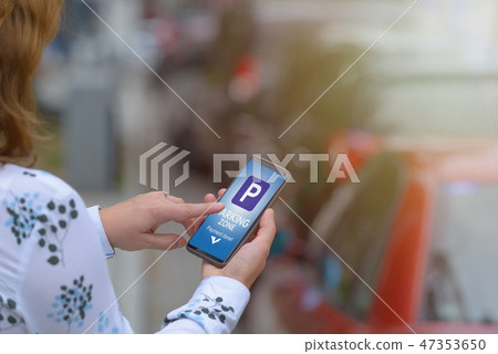 Woman using smartphone app to pay for parking 47353650