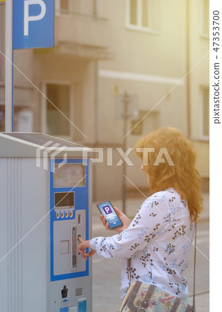 Woman using smartphone app to pay for parking 47353700