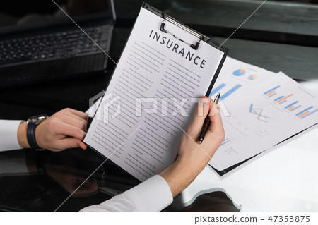 young man gets acquainted with terms of insurance in bright office 47353875