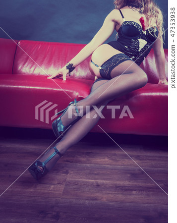 Woman wearing lingerie sitting on sofa, legs Woman wearing lingerie sitting on sofa, legs 47353938